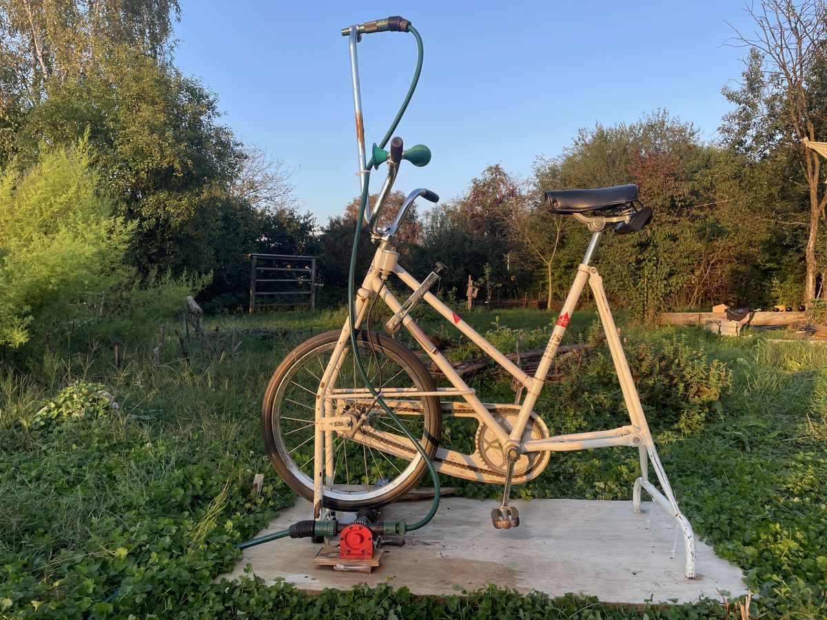 Vozi in zalivaj
Poganjaj enakomerno. Ko se sprednje kolo vrti, črpalka začne vleči vodo iz cisterne in jo potiskati skozi razpršilec. Z obračanjem krmila odločaš, kam bo padala voda—na gredo zelenjave, med mlade sadike ali po žejni gredici zemlje. Tvoja energija teče neposredno v zemljo, brez ovinkov elektrike ali goriva.