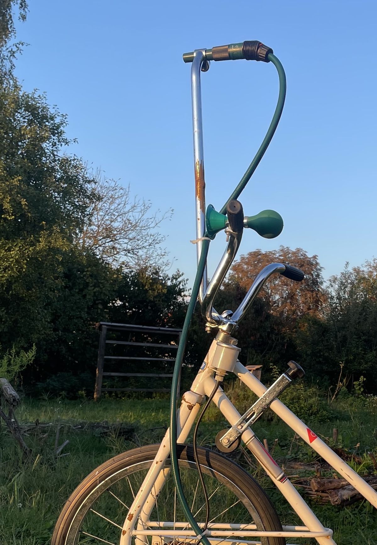 Namesti razpršilec
Izhodno cev spelji vzdolž krmila. Spredaj pritrdite preprost razpršilec ali šobo, tako da z usmerjanjem krmila hkrati usmerjaš tudi curek vode. Na ta način ne voziš čez prostor, temveč čez samo prst, zalivajoč tam, kjer želiš.